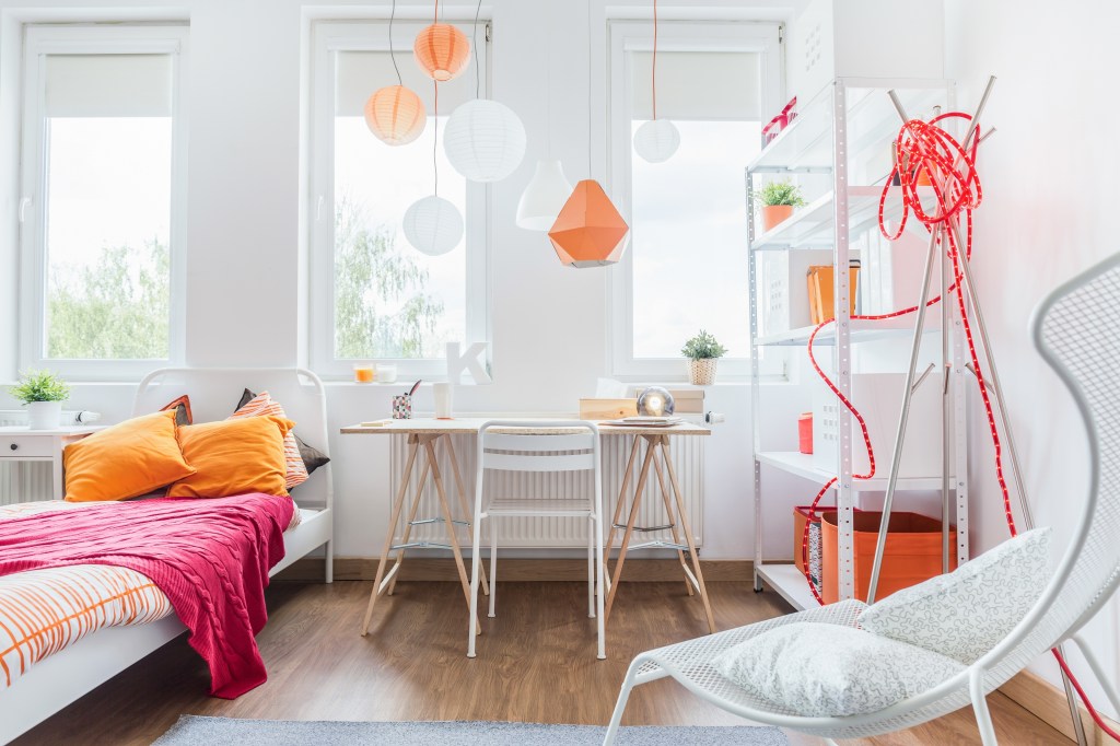 Light and airy teen bedroom with pink and orange accessories