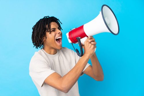 Teen Black teen boy in white teeshirt shouting into microphone