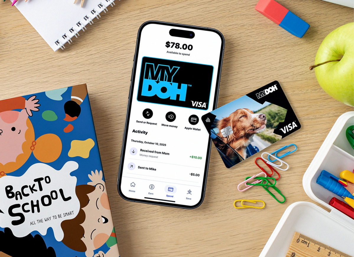 Flat lay mobile: app MyDoh affichant 78 $ disponibles, carte Visa et fournitures scolaires comme cahiers et pomme sur un bureau.