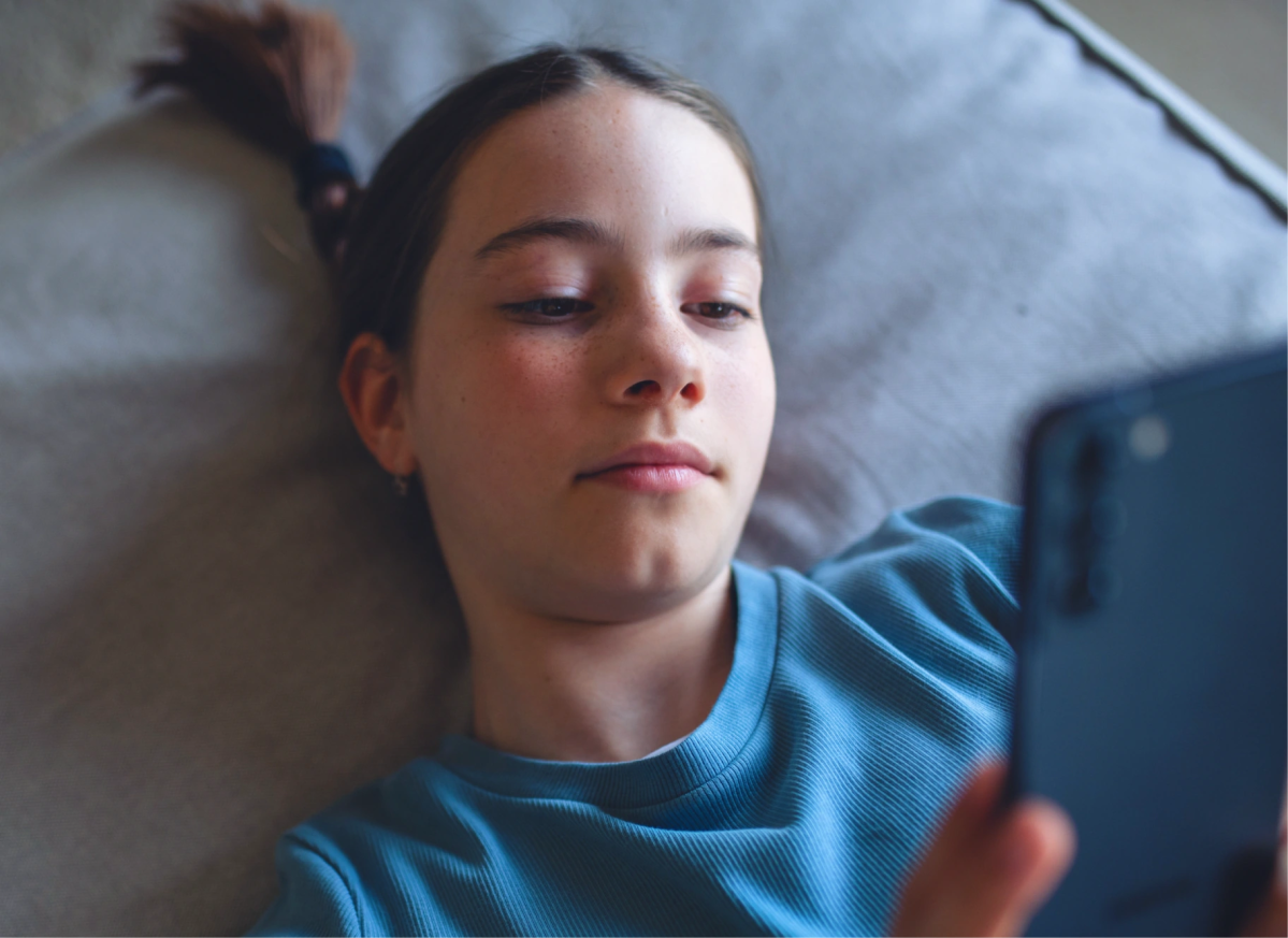 Un jeune allongé regarde un téléphone, montrant comment ça marche pour suivre l'argent et l'épargne avec l'application Mydoh.