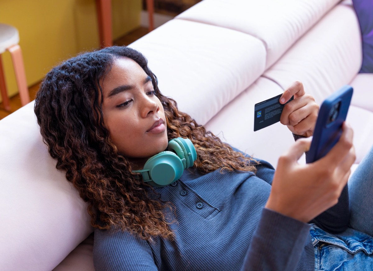 shows a person relaxing on a sofa while managing money on a smartphone with a MyDoh card and an inset app balance of $130.70.